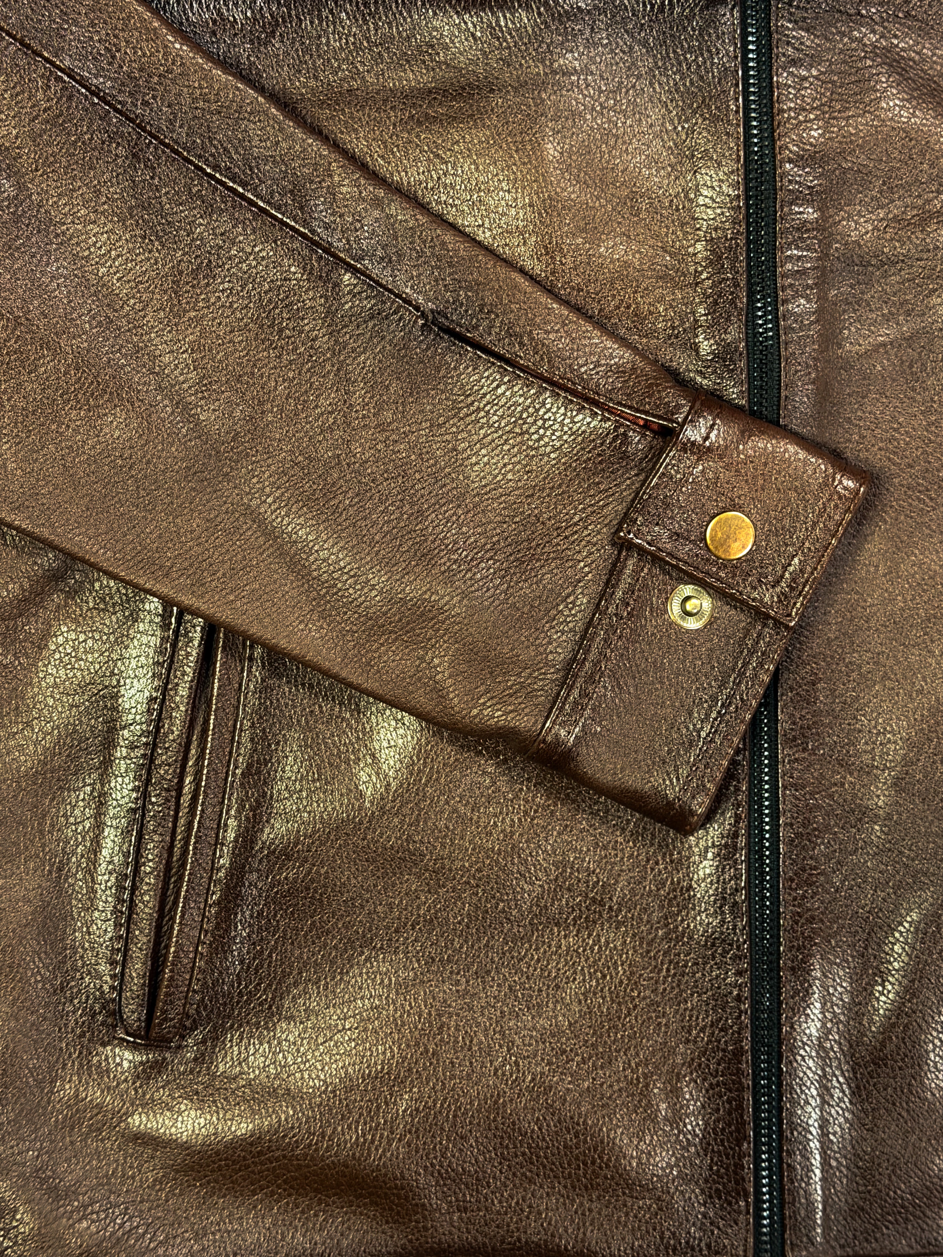 Close-up of a brown leather jacket with a zipper and button details.