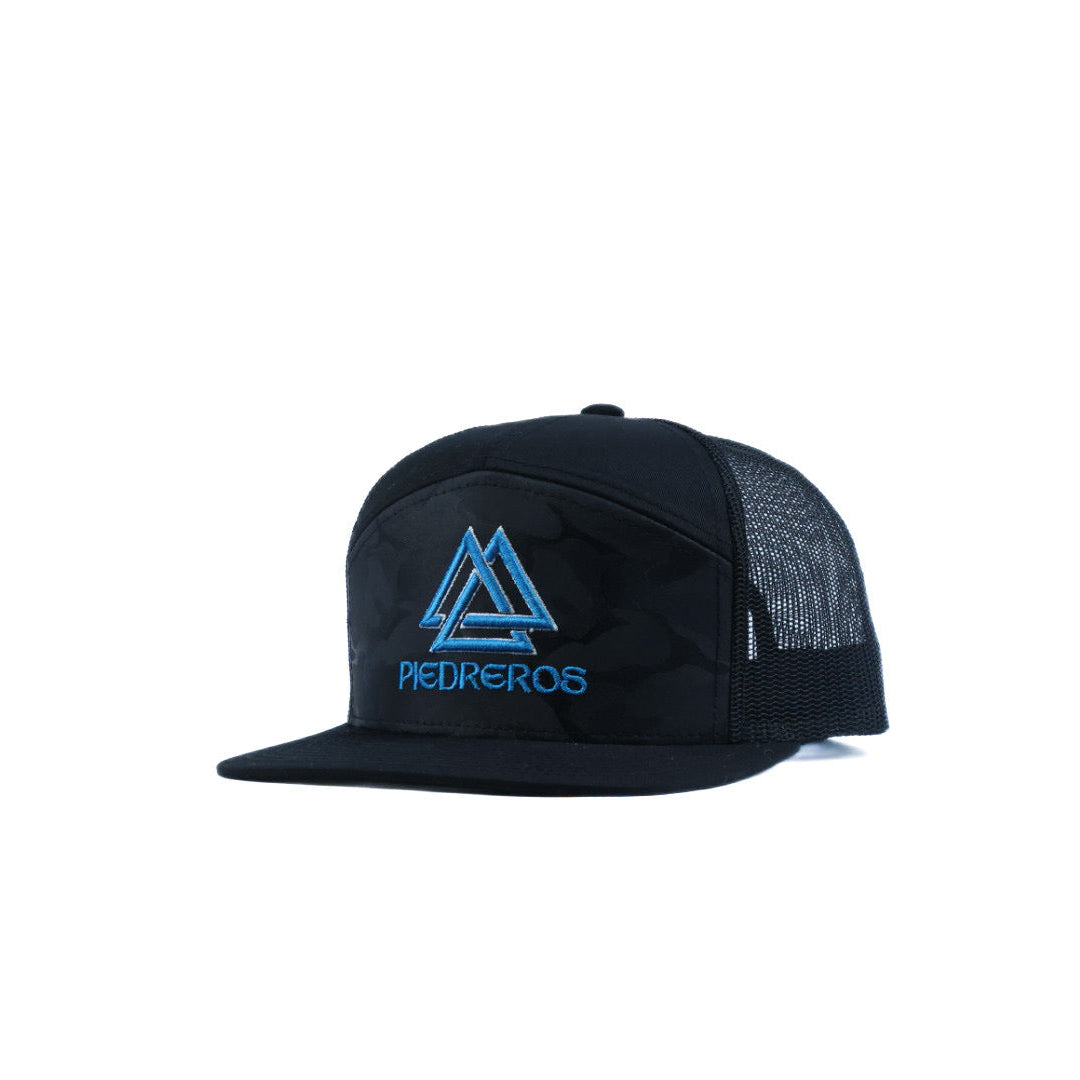 Black cap with blue piedreros logo on a camo 707 cap