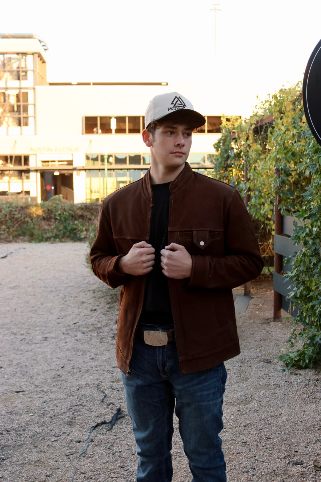 Person wearing a brown jacket and piedreros white and brown cap 