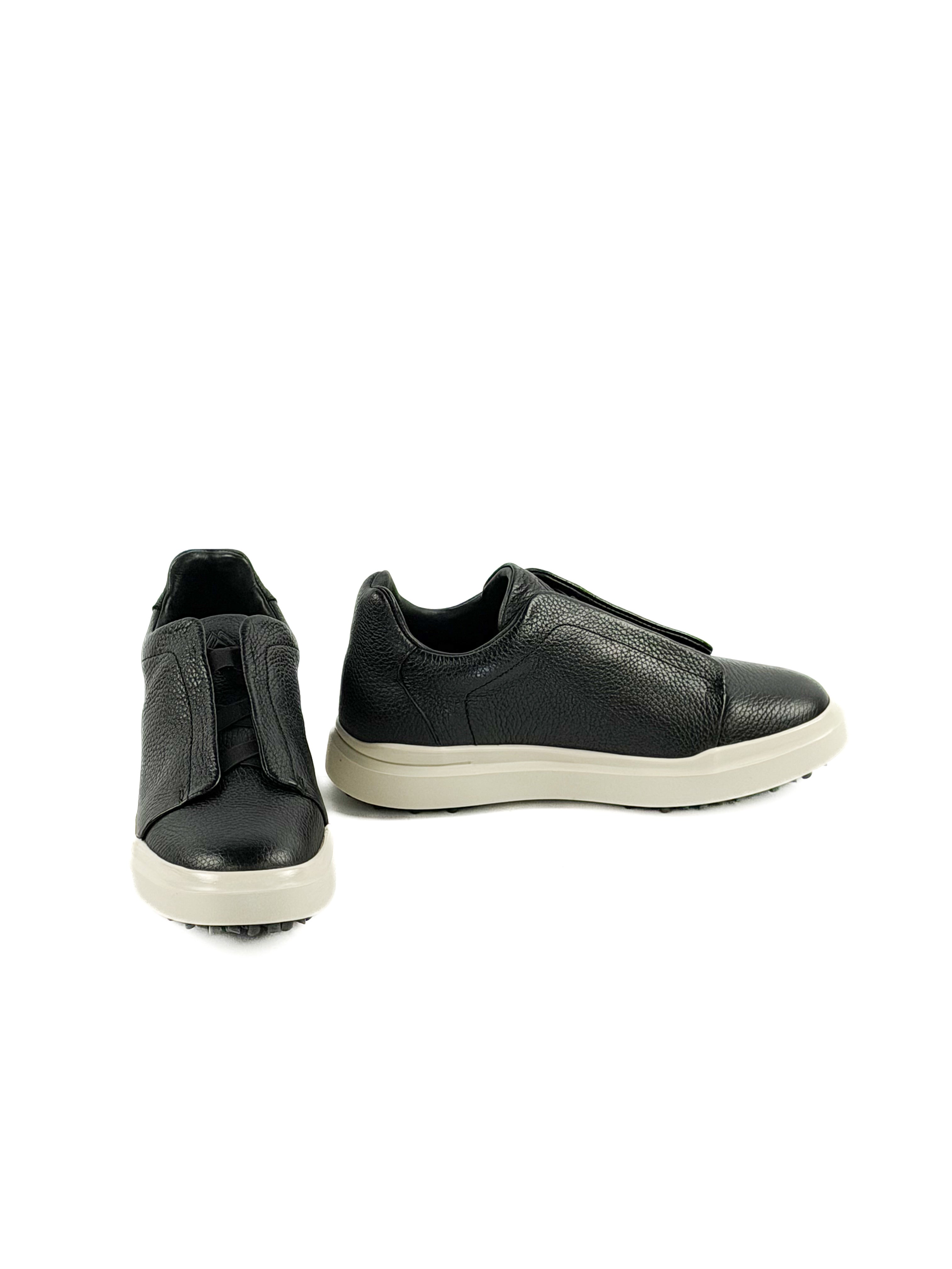 Pair of slip on black deer sneakers with durable traction