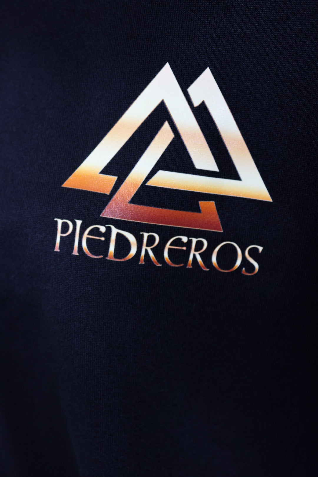 Close up of piedreros logo on sweater