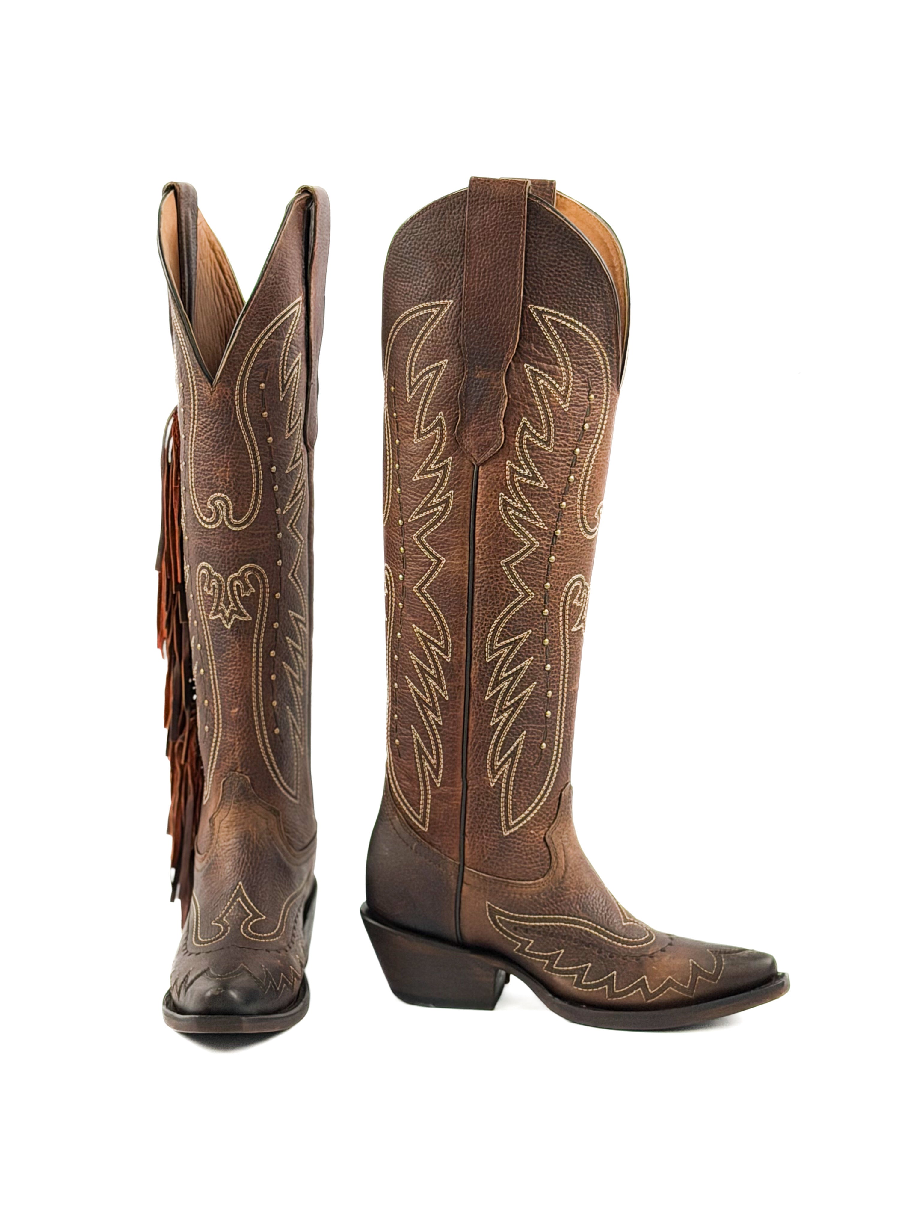 Pair of brown snip toe cowgirl boots with intricate designs, studs, fringes, and 2 inch heel.