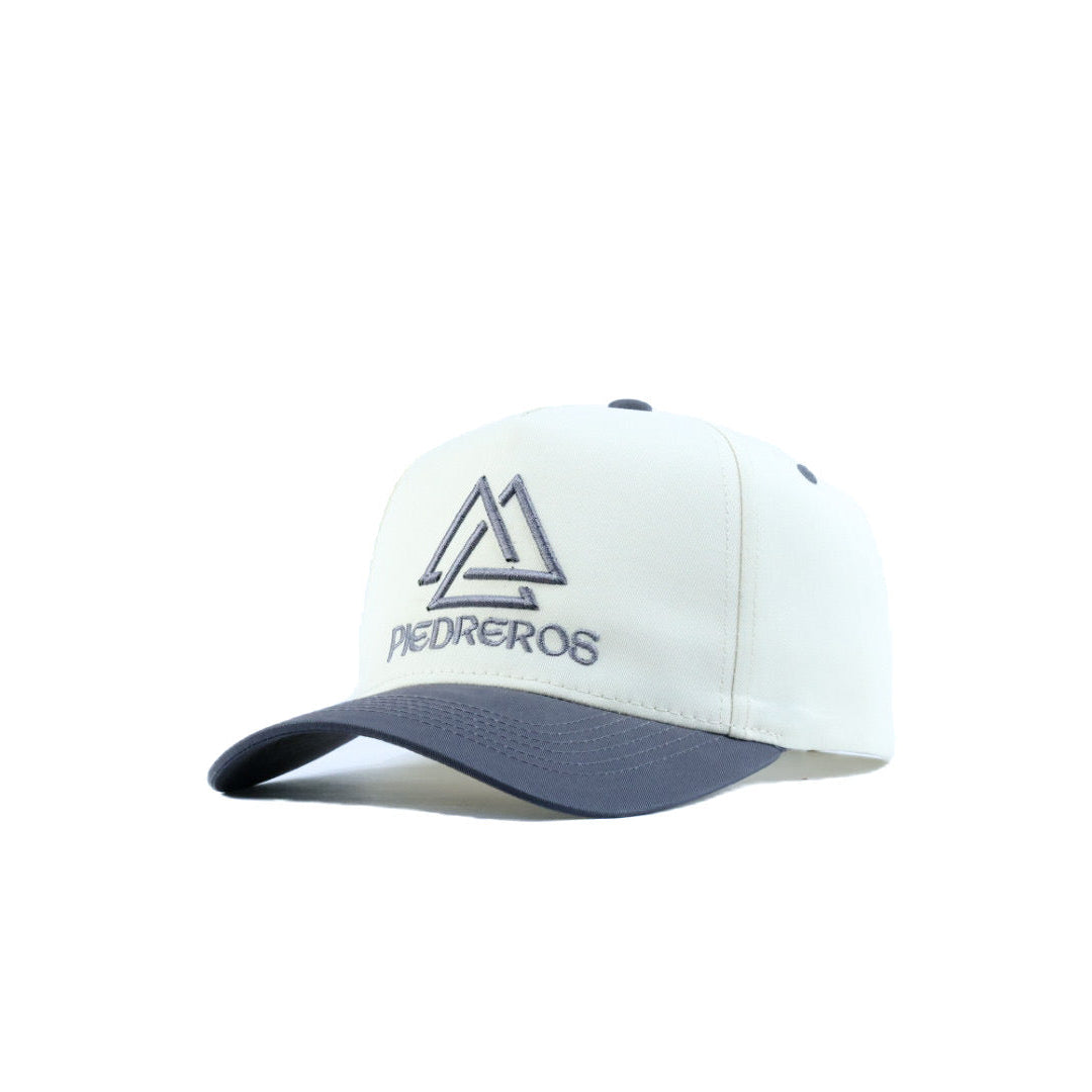 White cap with gray brim and 'Pedreros' logo on a white background