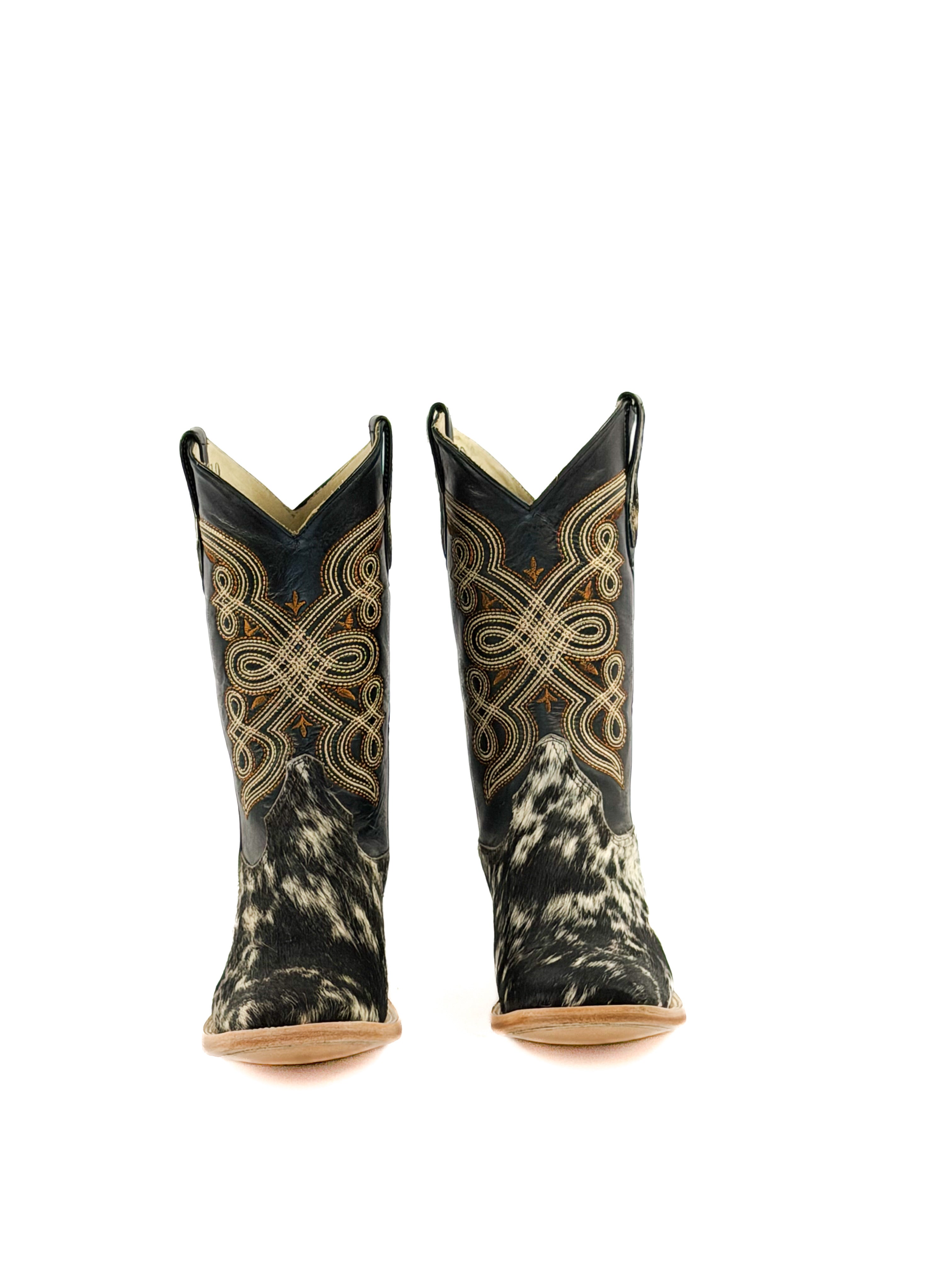 Pair of black and white cowhide square toe boots with intricate designs a black shaft