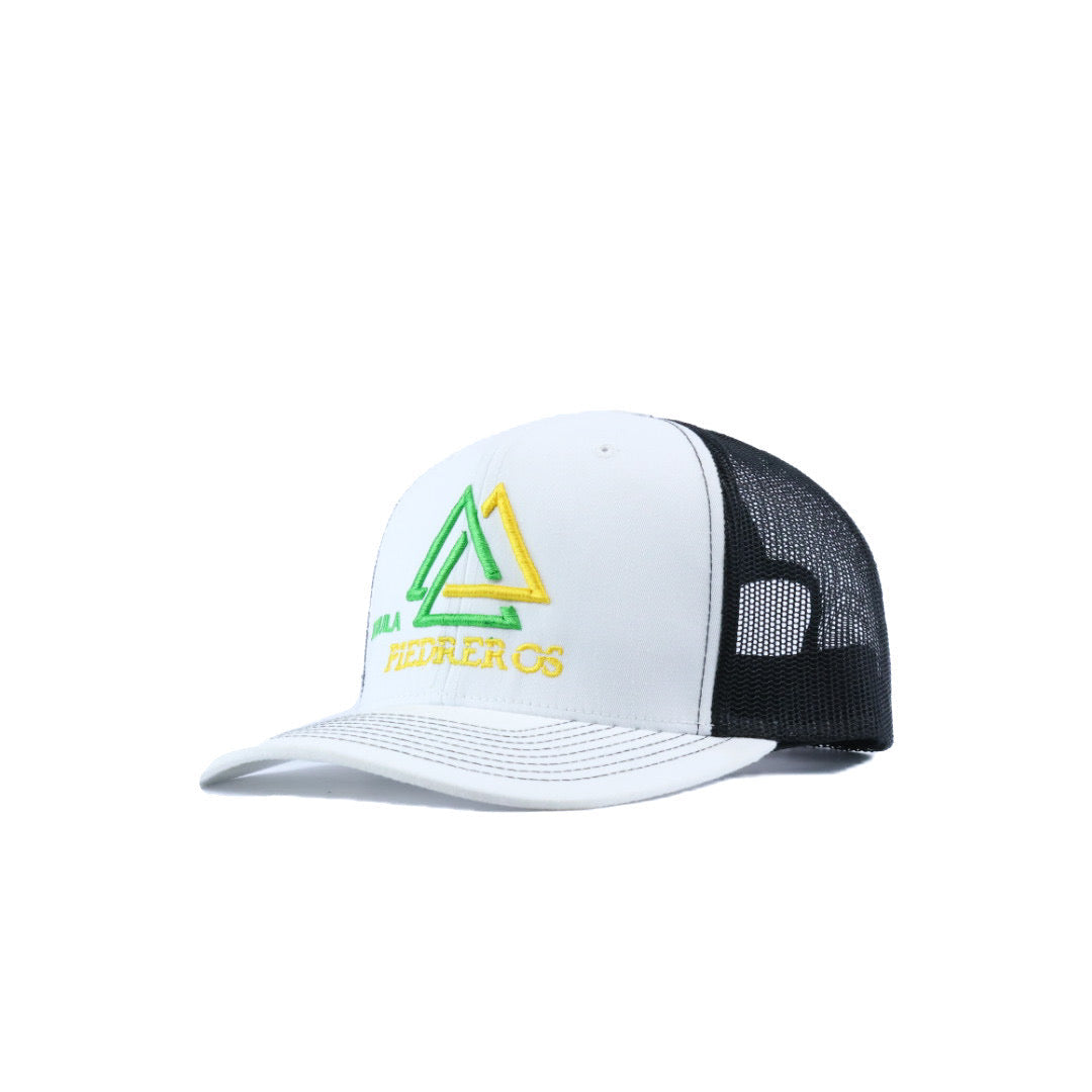 White and black cap with a yellow and green tequila piedreros logo 