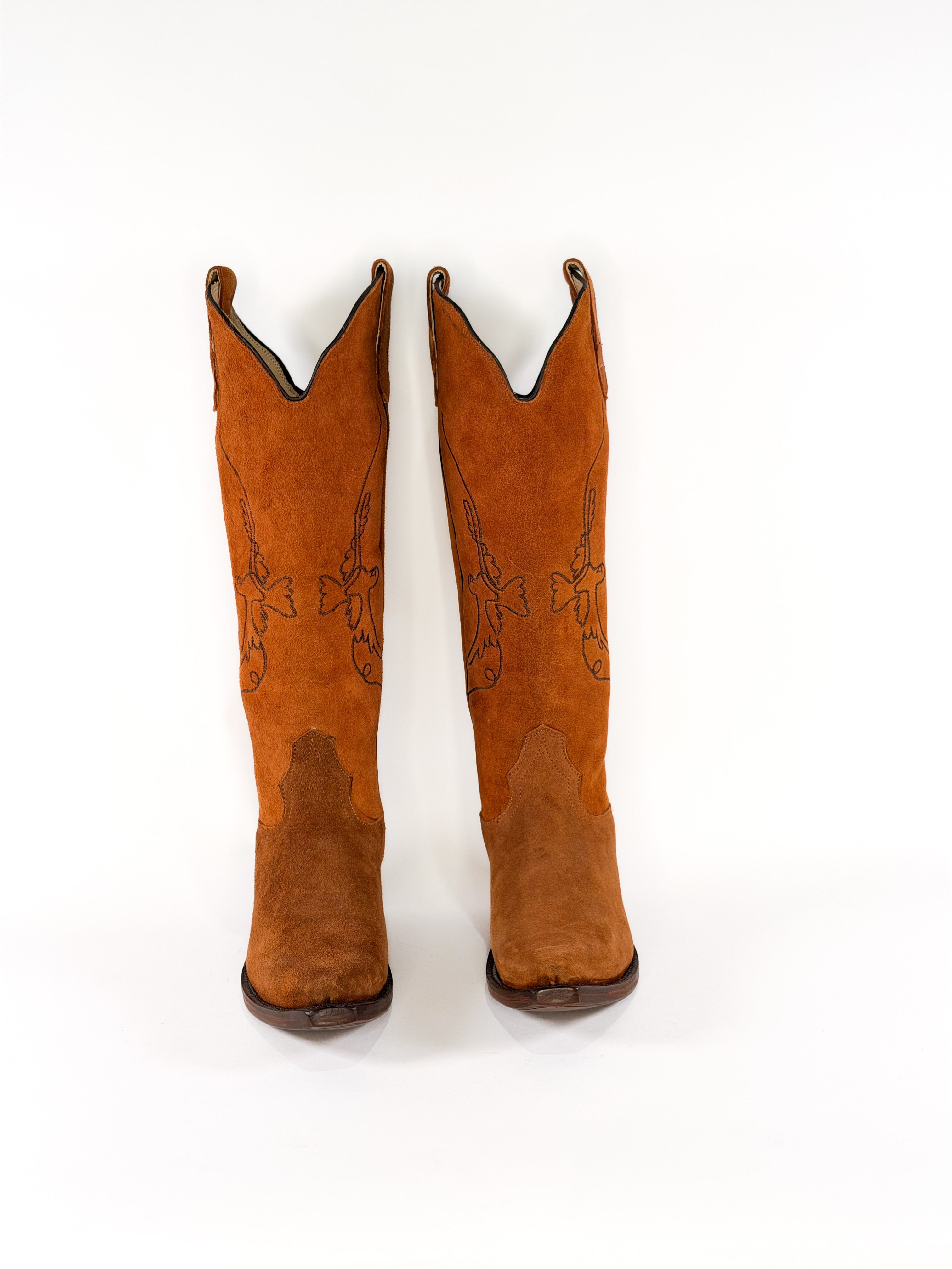pair of burnt amber suede cowgirl boots with gold bird detailing