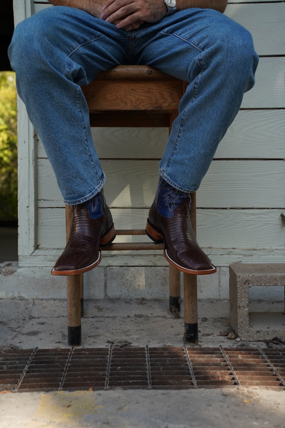 Pair of The Wharton boots on a stool with jeans